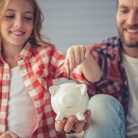 Father and daughter with piggy bank